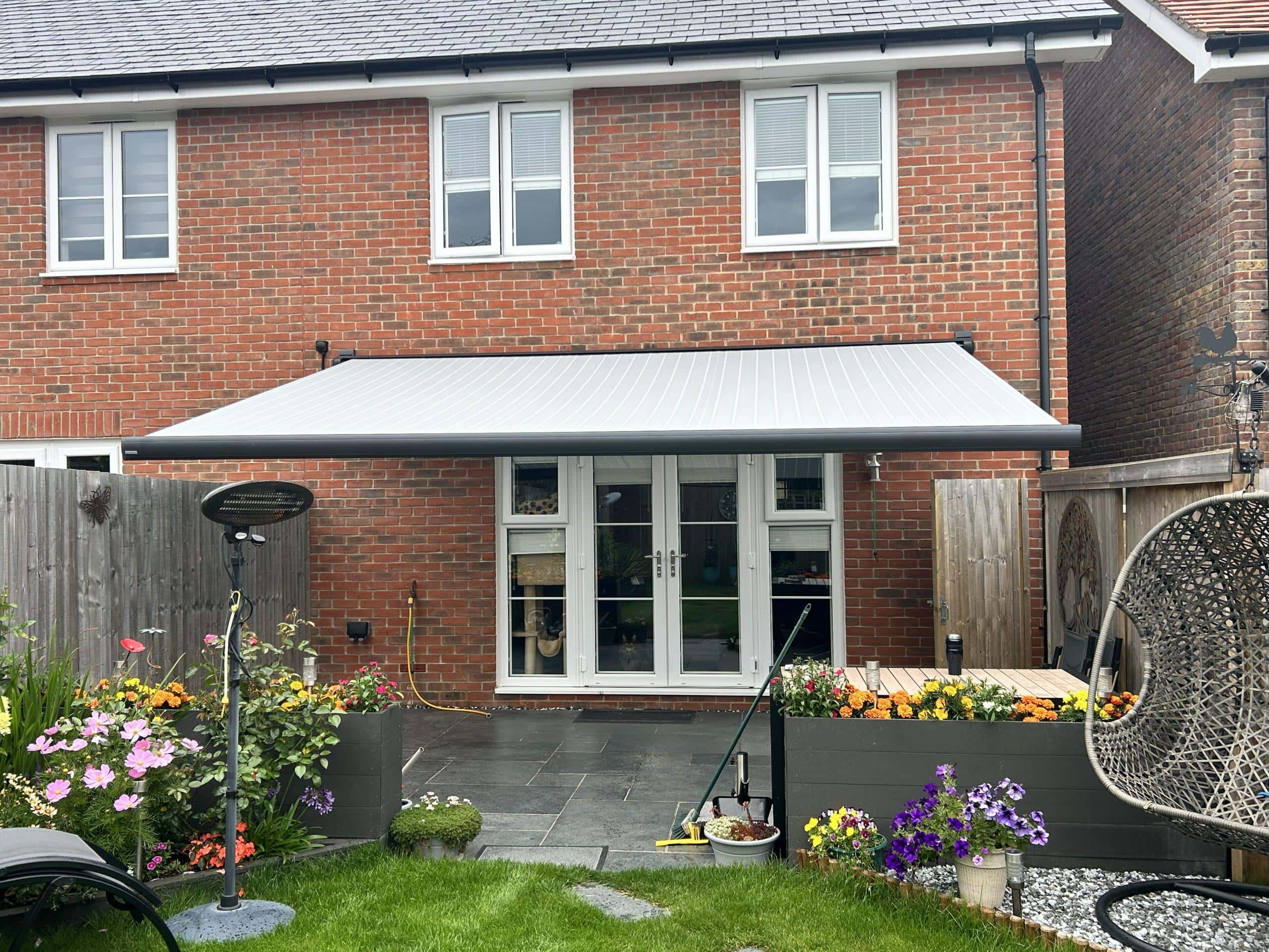 Modern retractable awning providing shade for garden patio area.
