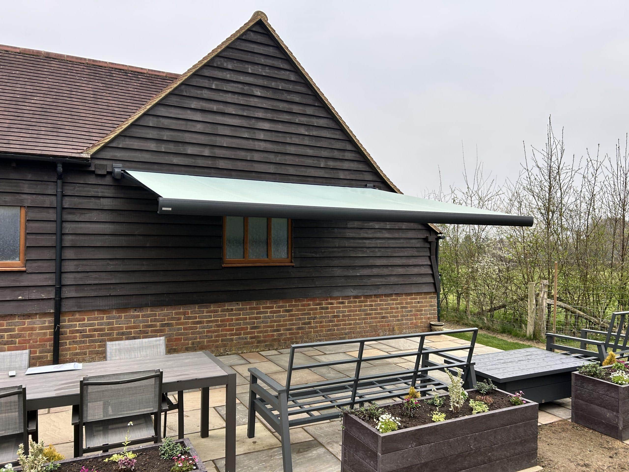 Outdoor shading system with retractable awning for garden or patio areas.