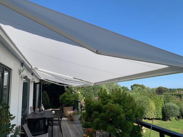Modern retractable awning providing shade for outdoor patio area.