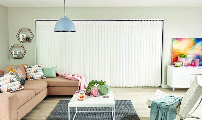 Modern living room with vertical blinds and shading solutions by Sovereign Shading Systems.