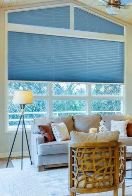 Blue window blinds with adjustable slats in a modern living room.