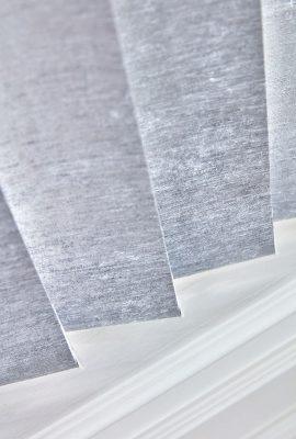 Close-up of grey fabric window blinds with sleek design and smooth texture.