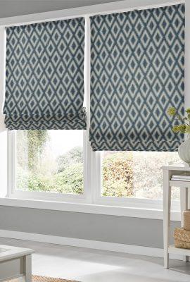Pair of patterned roller blinds in blue and beige with geometric diamond design.