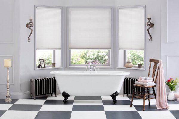 Elegant bathroom with white blinds on large bay windows, creating a bright and stylish space.