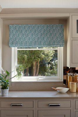 Blue patterned window blind for sun protection and privacy.