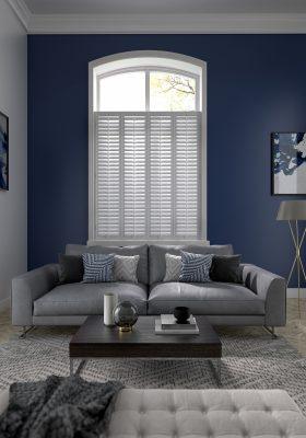Modern window with white plantation shutters in a contemporary living room.