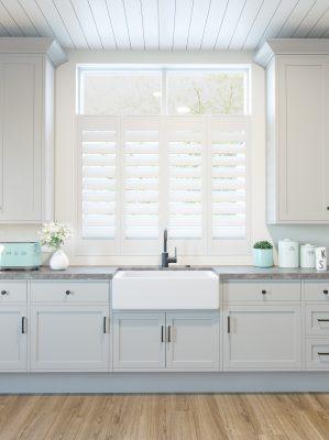 Modern white window shutters with adjustable slats in a bright kitchen setting.