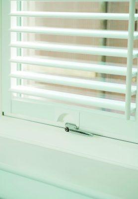 Modern white window blinds with adjustable slats for light control and privacy.