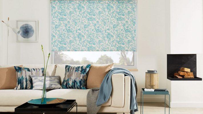 Modern window shading system with patterned roller blinds in a contemporary living room.
