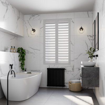 Elegant bathroom featuring a freestanding bathtub, marble walls, and natural light from a shuttered.