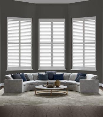 Elegant white window shutters with adjustable louvers in a contemporary living room setting.