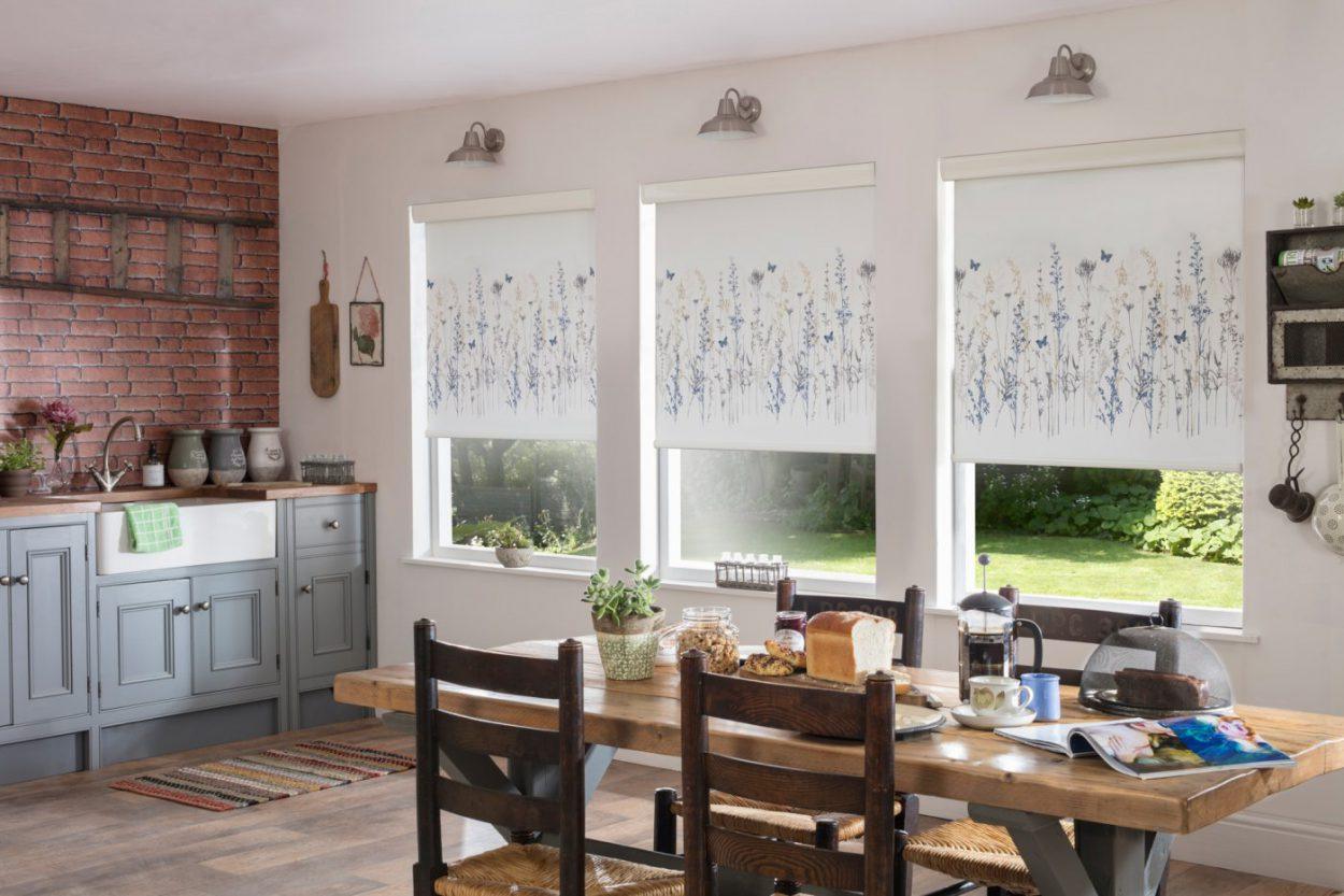 Modern roller blinds with floral patterns in a bright kitchen setting.