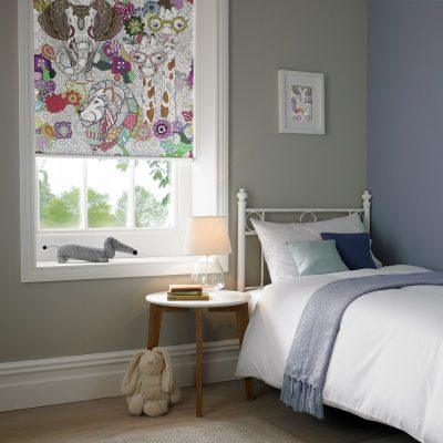 Bedroom with patterned window blind, soft bedding, and plush toys.
