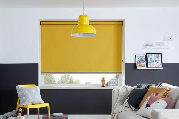 Modern yellow roller blind installed in a contemporary living room for sun shading and privacy.