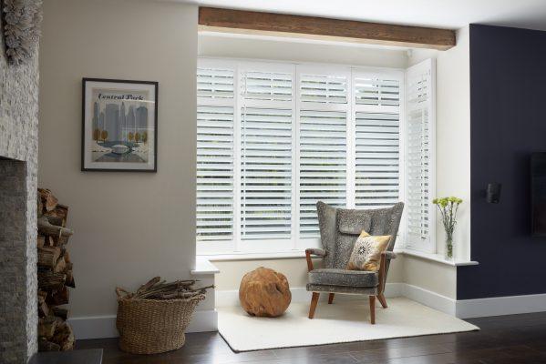 Modern window shading system with white blinds in a stylish living room.