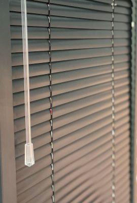 Close-up of sleek grey window blinds with pull cord, showcasing quality shading solutions.