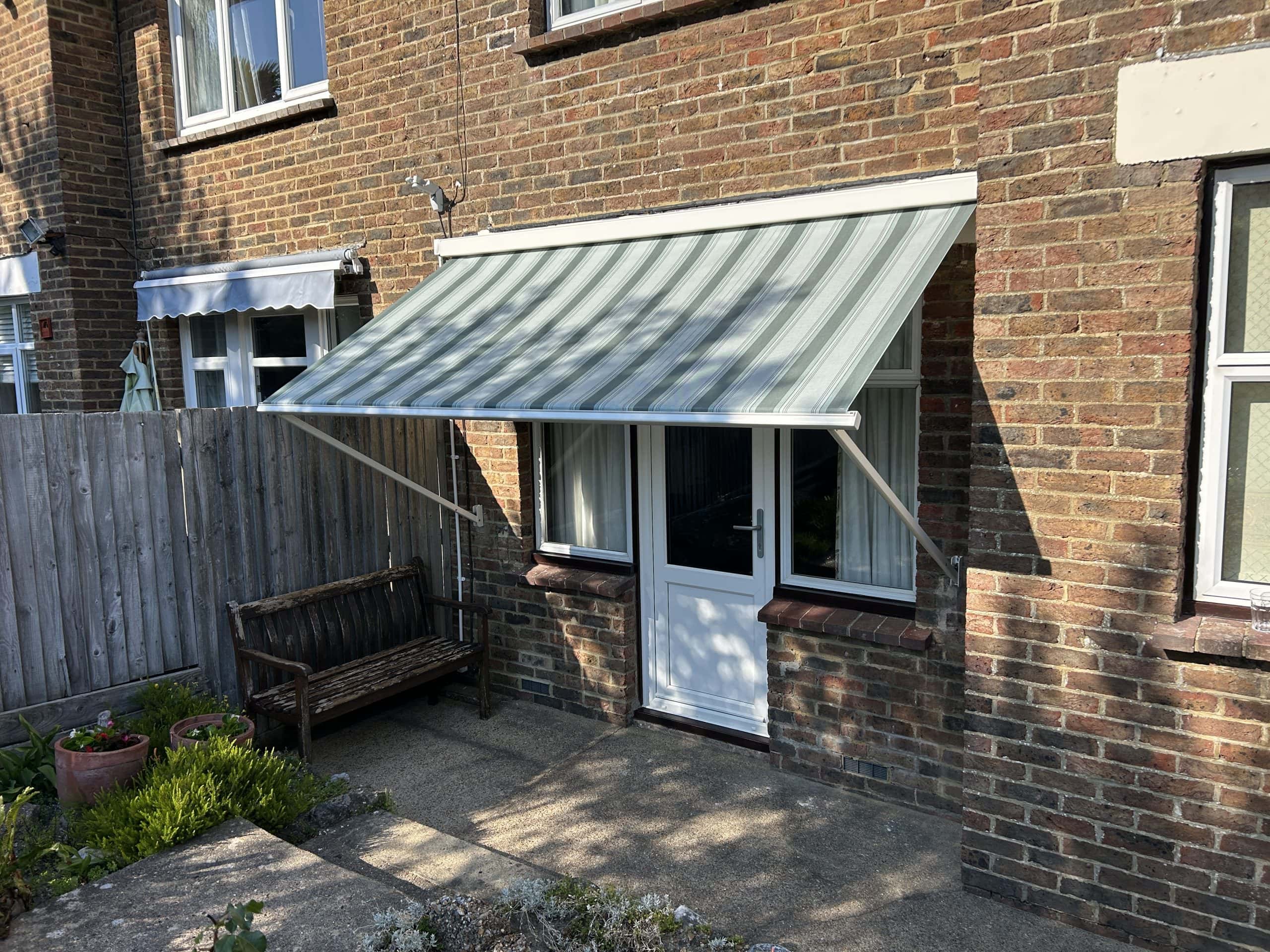 Outdoor awning by Sovereign Shading Systems on brick house.